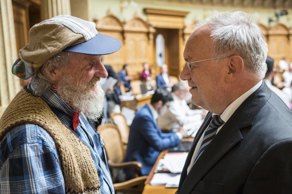 Bergbauer Armin Capaul, links, diskutiert nach der Debatte zur von ihm eingereichten Hornkuh-Initiative mit Bundesrat Johann Schneider-Ammann, an der Sommersession der Eidgenoessischen Raete, am Monta ...