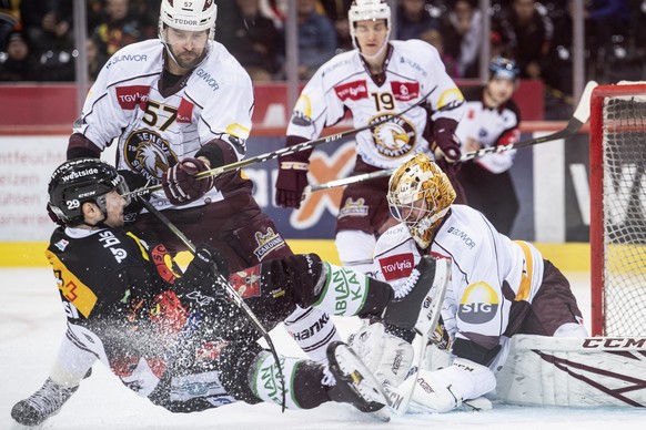 Berns, Daniele Grassi, links, im Duell mit Servettes, Goran Bezina, Mitte, und Goalie Robert Mayer, rechts, waehrend dem Playoff Viertelfinal, Spiel 1, der National League zwischen dem SC Bern und dem ...