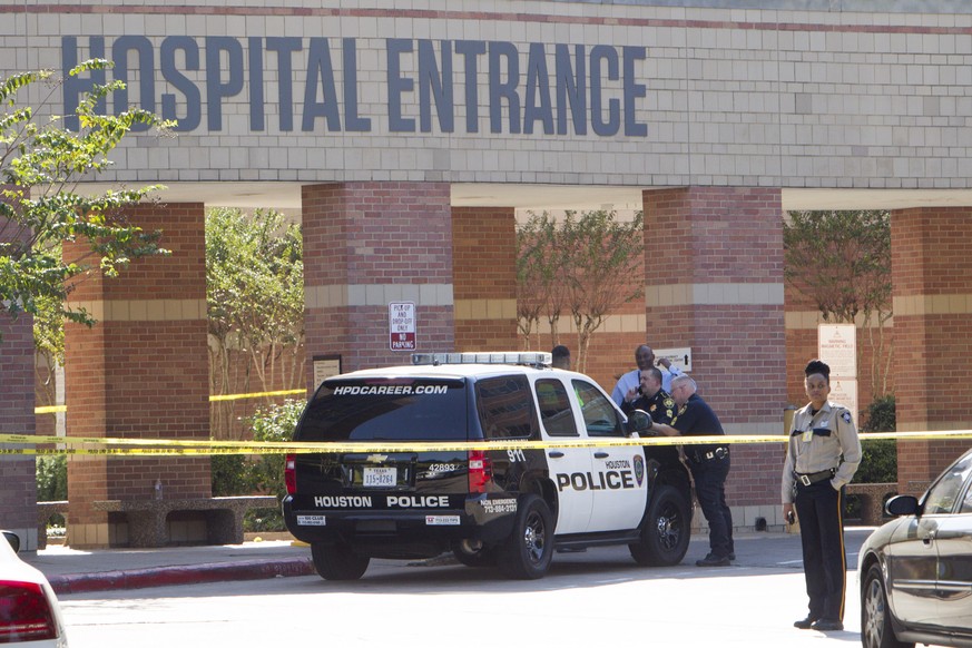 Law enforcement officers stand outside Ben Taub General Hospital following a shooting in the outpatient pharmacy on Wednesday, Oct. 22, 2014, in Houston. Police say a man walked up to a female co-work ...