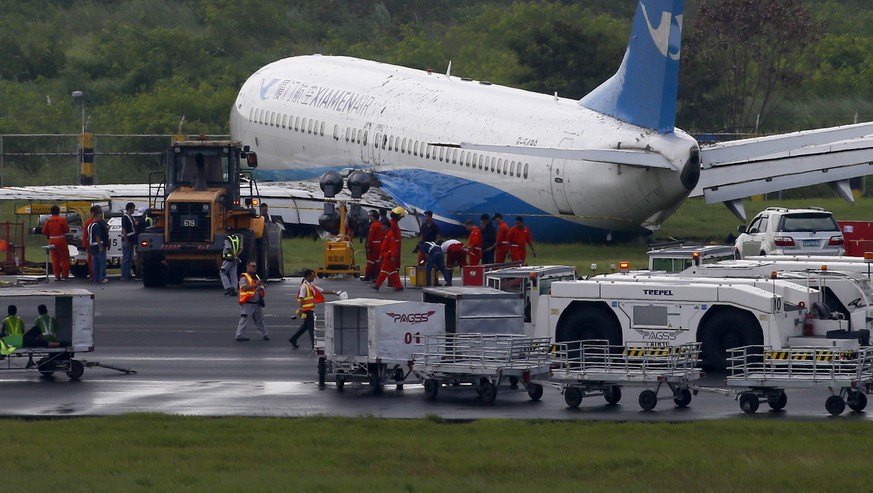 Xiamen Air, a Boeing passenger plane from China, sits on the grassy portion of the runway of the Ninoy Aquino International Airport after it skidded off the runway while landing Friday, Aug. 17, 2018  ...