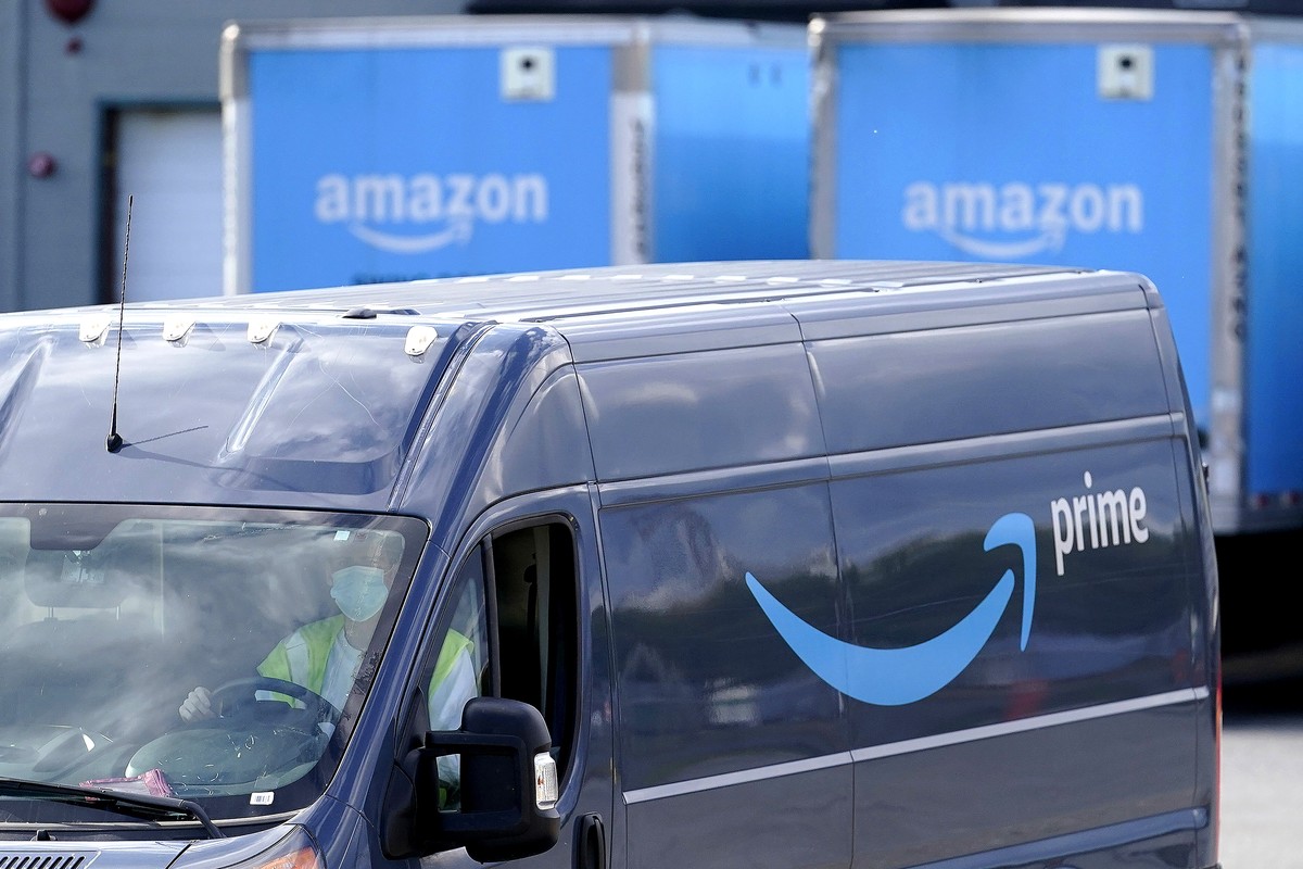 FILE - An Amazon Prime logo appears on the side of a delivery van as it departs an Amazon Warehouse location in Dedham, Mass., Oct. 1, 2020. Amazon has complained to federal regulators that they are h ...