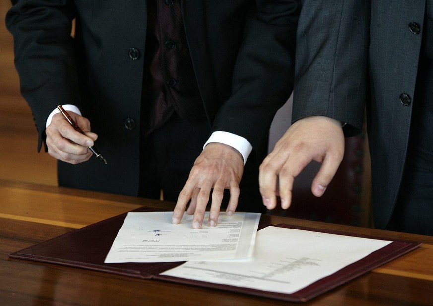 Raphael Costaz, gauche et Bladymir Corrales, droite, devant Laura Da Broi, gauche officier de l&#039;Etat civil signe les differents document durant la ceremonie de leurs partenariat enregistre sur le ...