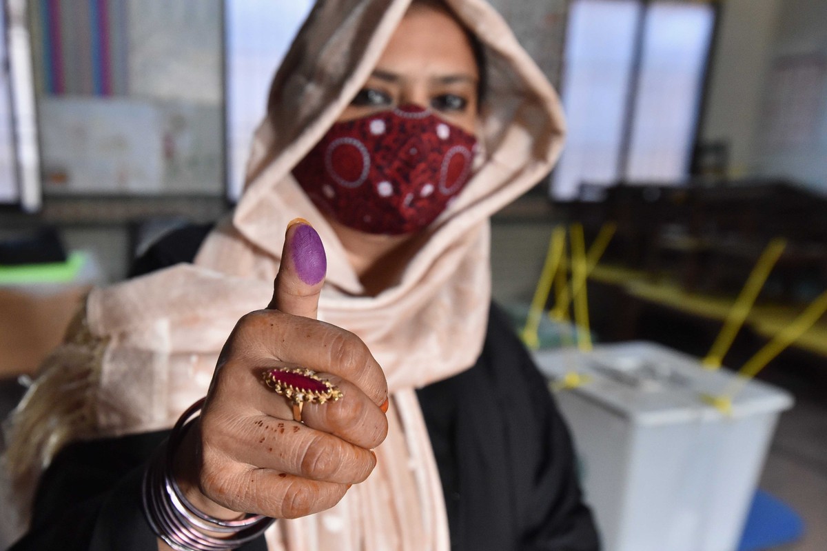 epa11135593 A voter shows her thumb after casting a ballot at a polling station during general elections in Karachi, Pakistan, 08 February 2024. Pakistani voters headed to heavily guarded polling stat ...