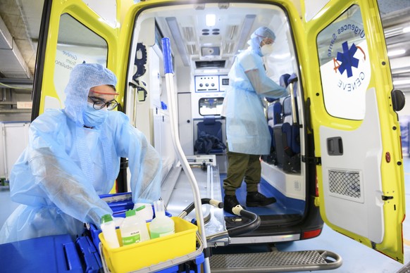 epa08827429 Members of the Swiss civil protection wearing personal protective equipment disinfect an ambulance dedicated to transporting patients with COVID-19, at the Geneva University Hospitals (HUG), during the coronavirus disease (COVID-19) pandemic, in Geneva, Switzerland, 18 November 2020. Switzerland, as many countries in Europe, requisitioned members of the Civil Protection, the Swiss army and also firefighter to help medical workers in hospitals as cases of Covid-19 patients spike in a second wave of pandemic.  EPA/LAURENT GILLIERON