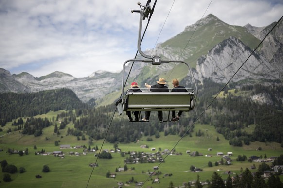 Touristen nehmen den Sessellift vom Berggasthaus Oberdorf nach Wildhaus, mit Blick auf den Saentis, aufgenommen am Montag, 31. Juli 2023, in Wildhaus-Alt St. Johann. (KEYSTONE/Gian Ehrenzeller)