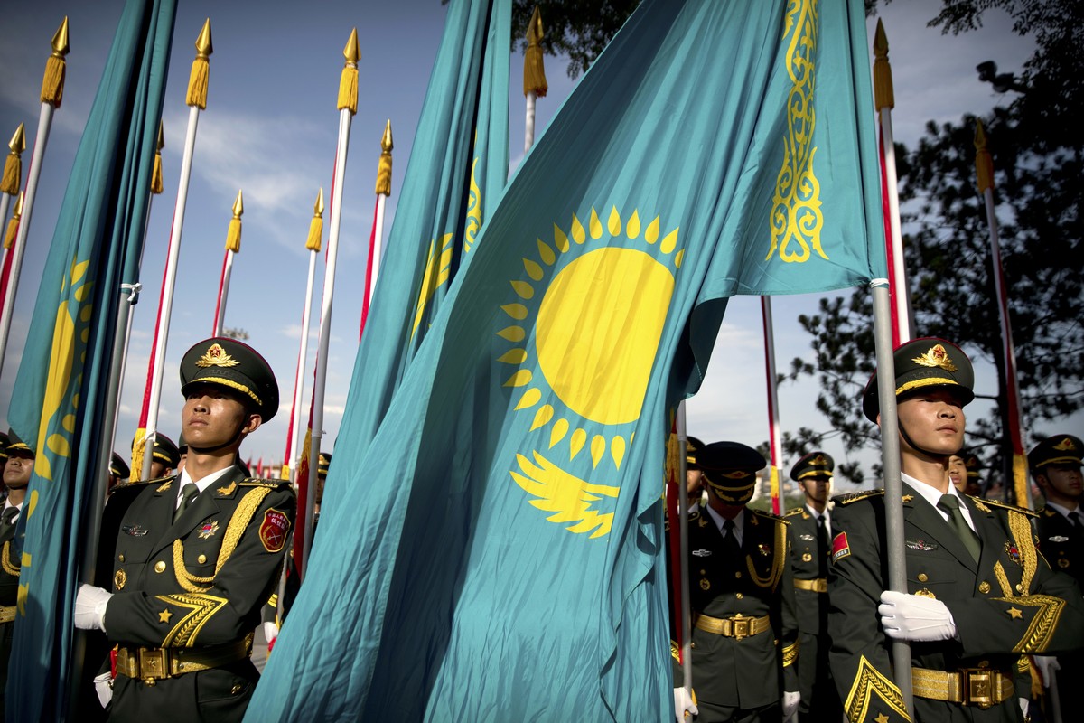 FILE - A Kazakhstan flag blows in the breeze as members of a Chinese honor guard line up in formation before a welcome ceremony for Kazakhstan's President Nursultan Nazarbayev at the Great Hall o ...