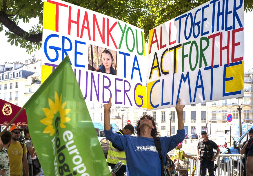 A climate activist holds a placard reading &quot;Thank You Greta Thunberg &quot; next to the french National Assembly during Greta Thunberg&#039;s visit in Paris, France, Tuesday, July 23, 2019. (AP P ...