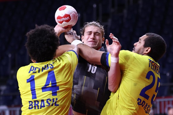 epa09385306 Juri Knorr of Germany (C) in action against Thiagus Petrus (L) and Vinicius Teixeira of Brazil during the Men&#039;s Handball preliminary round match between Germany and Brazil at the Toky ...