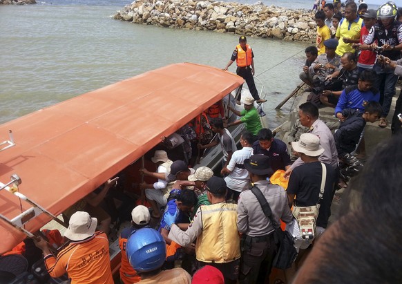 Ein Boot bringt die Leiche eines Opfers des Schiffsunglück vor der indonesischen Insel Sulawesi an Land.