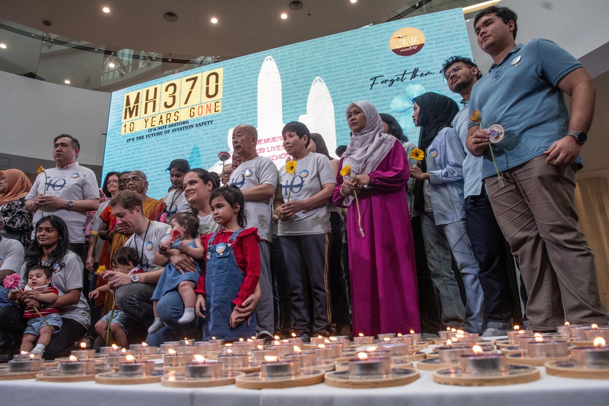 epa11196247 Family members of passengers and crew on board missing Malaysian Airlines flight MH370 and Malaysia?s Transport Minister, Loke Siew Fook (second row, 2-L), stand together for a group photo ...