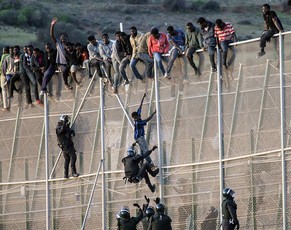 Spanische Polizisten&nbsp;– für ihr rigoroses Vorgehen bekannt&nbsp;– holen Flüchtlinge vom Grenzzaun.