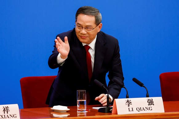 epa10519358 Chinese Premier Li Qiang stands up to leave after a news conference following the closing session of the National People&#039;s Congress (NPC), at the Great Hall of the People, in Beijing, ...