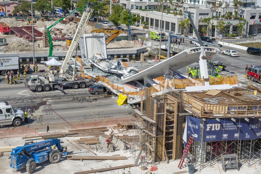 epaselect epa06606821 Emergency personnel works on a collapsed pedestrian bridge on the Florida International University in Miami, Florida, USA on 15 March 2018. A recently installed pedestrian bridge ...