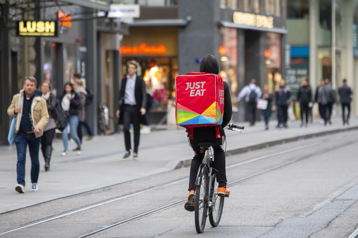Un coursier a velo partenaire de la societe Eat.ch by Just Eat roule dans les Rues Bases pour aller livrer un repas a domicile, ce lundi 16 mars 2020 a Geneve. (KEYSTONE/Salvatore Di Nolfi)