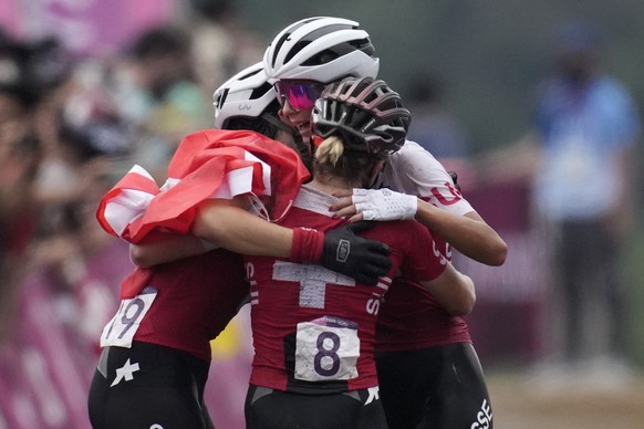 Jolanda Neff of Switzerland hugs teammates Sina Frei (8) who won silver, and Linda Indergand (19) who won bronze, for a sweep of the podium for Switzerland, at the finish line the women&#039;s cross-c ...