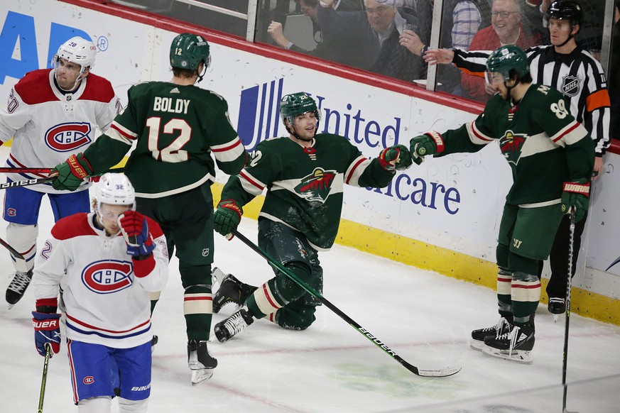 Minnesota Wild left wing Kevin Fiala (22) is congratulated by teammates center Frederick Gaudreau (89) and left wing Matt Boldy (12) as Montreal Canadiens center Rem Pitlick (32) and defenseman Chris  ...