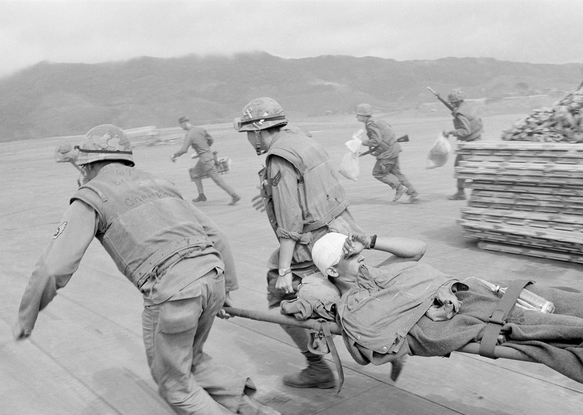 FILE - In this Feb. 11, 1968, file photo, Air Force medics race across open ground past bunkers beside Khe Sanh airstrip carrying badly wounded Marines to plane while under sniper fire from guerrillas ...