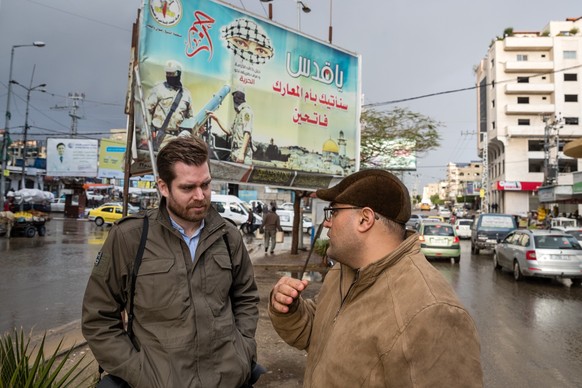 Kühni (links) ende 2018 in Gaza Stadt im Gespräch mit einem Palästinensischen Übersetzer. Im Hintergrund ein Plakat der Terror Organisation «Islamischer Dschihad».
