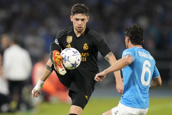 Napoli&#039;s Mario Rui, right, challenges Real Madrid&#039;s Federico Valverde during the Champions League group C soccer match between Napoli and Real Madrid at the Diego Armando Maradona stadium in ...
