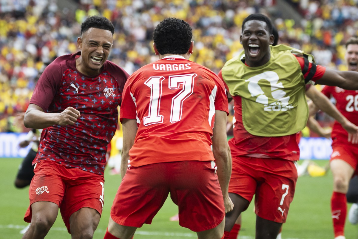 Switzerland's Ruben Vargas celebrates with teammates Dan Ndoye, left, and Breel Embolo after scoring the final penalty shot during the World Cup round of 16 soccer match between Switzerland and C ...
