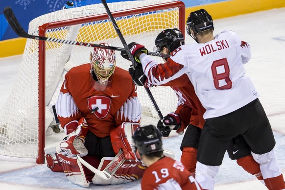 Jonas Hiller, goalkeeper of Switzerland, Reto Schaeppi of Switzerland, Patrick Geering of Switzerland, and Wojtek Wolski of Canada, from left, during the men ice hockey preliminary round match between ...