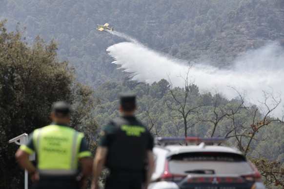 epa13139183 A plane drops water on a wildfire burning near the Santa Barbara chapel at La Vall d'Uixo in Castellon, Spain, 29 July 2026. EPA/MANUEL BRUQUE