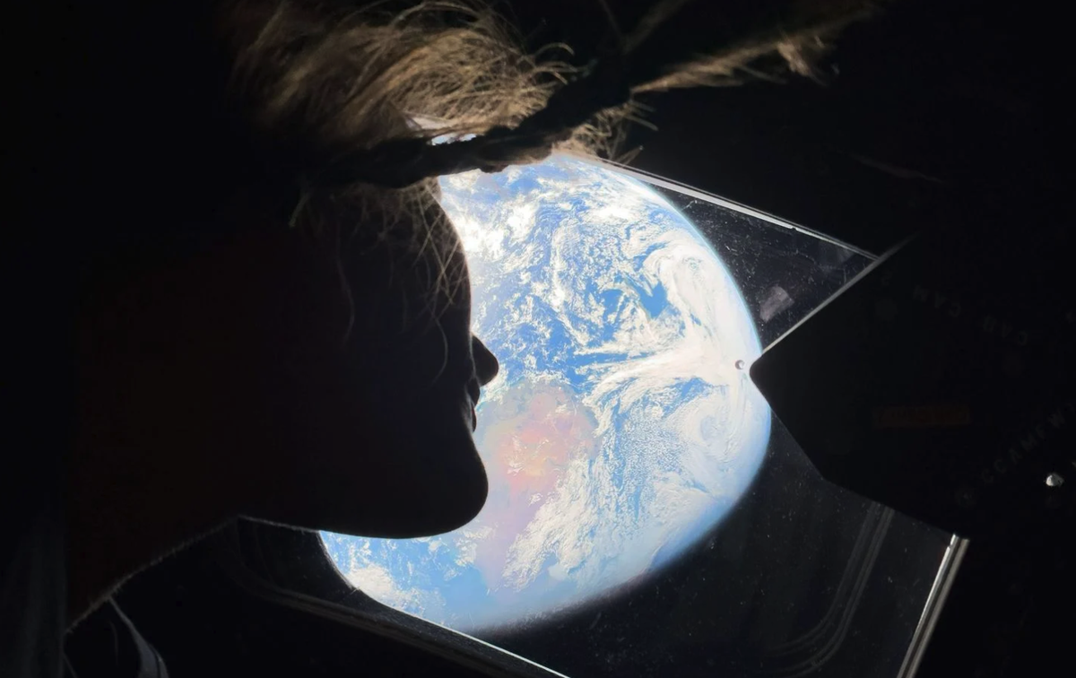 L’astronaute de la Nasa Christina Koch regarde par la fenêtre principale de la cabine du vaisseau Orion, regardant la Terre.