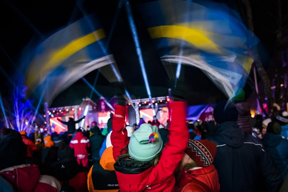 People celebrate with de flag of Sweden during the opening ceremony at the 2019 FIS Alpine Skiing World Championships in Are, Sweden Monday, February 4, 2019. (KEYSTONE/Jean-Christophe Bott)