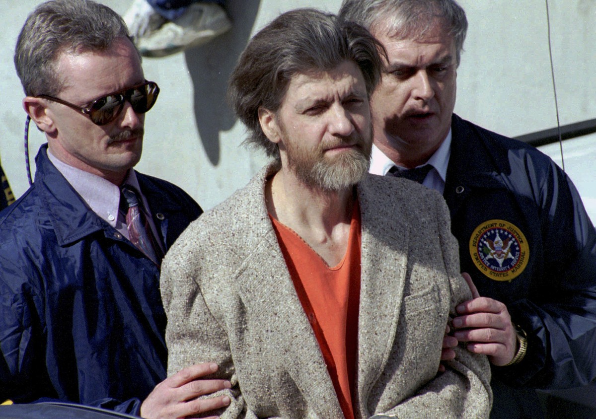 FILE - Theodore "Ted" Kaczynski is flanked by federal agents as he is led to a car from the federal courthouse in Helena, Mont., April 4, 1996. A spokesperson for the Bureau of Prisons on Sa ...