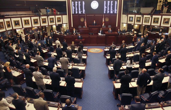 FILE - Members of the House of Representatives rise for prayer at the opening of a special session, Aug. 7, 2014, at the Capitol in Tallahassee, Fla. A stripper and the strip club where she worked hav ...