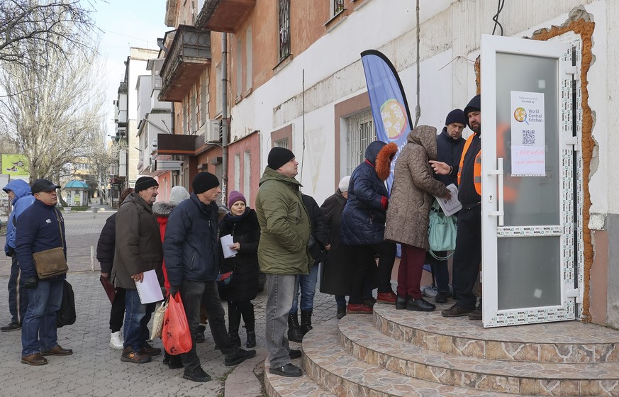 epa10373928 Locals queue to receive humanitarian aid distributed by Ukrainian volunteers in Kherson, southern Ukraine, 19 December 2022 amid the Russian invasion. Ukrainian troops entered Kherson on 1 ...