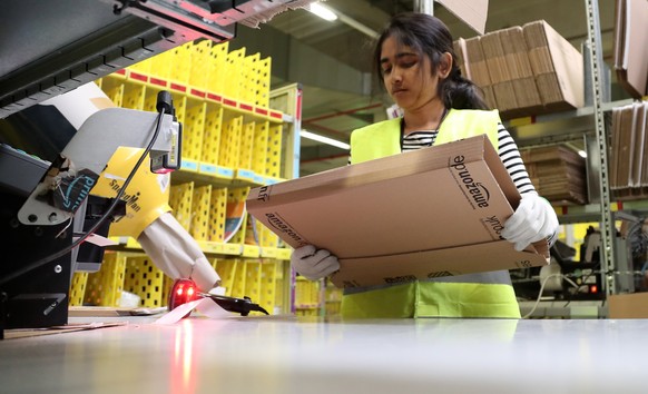 epa06355788 A worker at the Amazon logistics and distribution center in Rheinberg, Germany, 28 November 2017. The Amazon logistics center is directly connected to a &#039;Deutsche Post&#039; DHL shipp ...