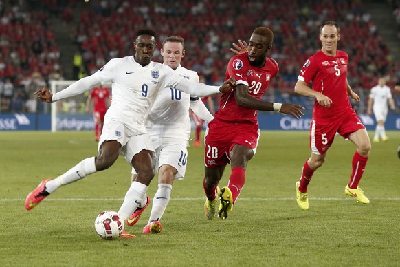 Swiss defenders Steve Von Bergen, right, and Johan Djourou, center right, fight for the ball against England's Wayne Rooney, center, and Danny Welbeck, left, during the UEFA EURO 2016 qualifying match Switzerland against England at the St. Jakob-Park stadium in Basel, Switzerland, Monday, September 8, 2014. (KEYSTONE/Peter Klaunzer)