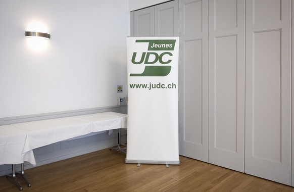 Ein Plakat mit dem Logo der &quot;Jeunes UDC&quot; steht im Konferenzraum, waehrend einer Medienkonferenz der Jungen SVP zum Stimmrechtsalter 16 im Kanton Bern, am Mittwoch, 10. August 2022 in Bern. ( ...