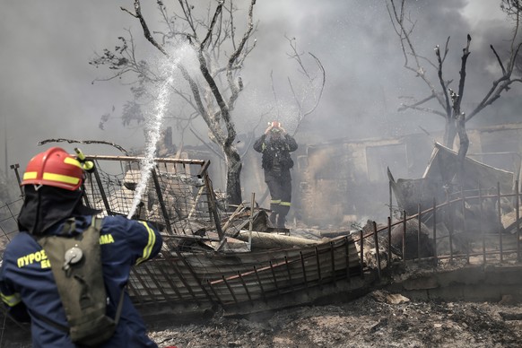 epa10815454 Firefighters try to extinguish a fire at a residential area located at the foot of Parnitha mountain in the outskirts of Athens, Greece, 23 August 2023. Fire Brigade forces continue to bat ...