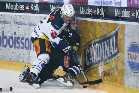 Zugs Thomas Thiry, links, im Kampf mit Fribourgs Julien Privet, im Eishockey Meisterschaftsspiel der National League zwischen dem HC Fribourg Gotteron und dem EV Zug, am Samstag, 13. Januar 2018, in d ...