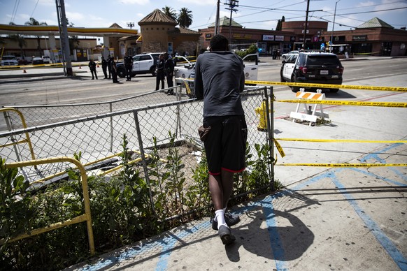 epa07481231 A man waits behind police tape at Slauson Avenue and Crenshaw Boulevard intersection to be reopened to pay their respect after Nipsey Hussle was shot dead in front of his shop &#039;The Ma ...