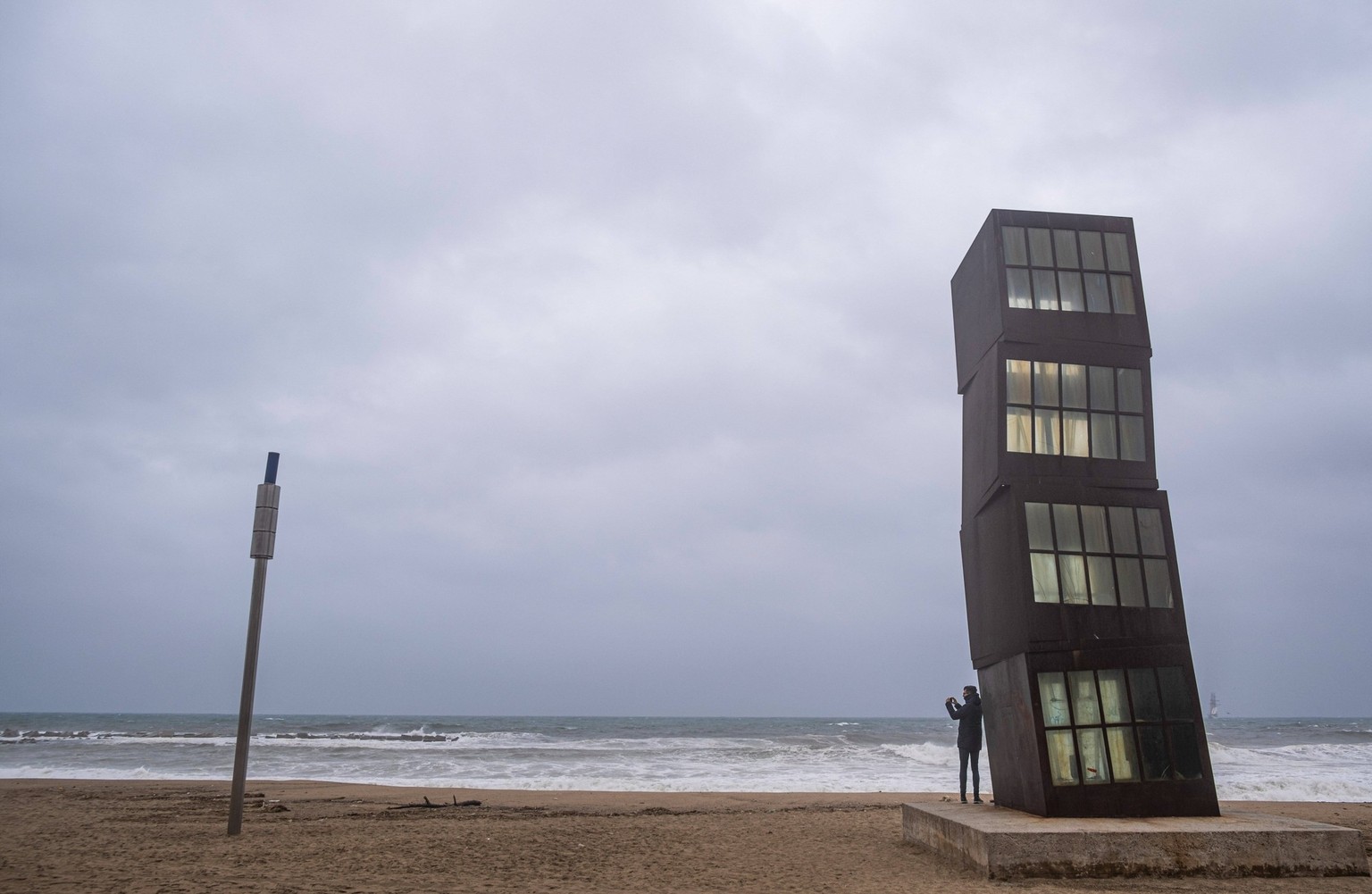March 15, 2022, Barcelona, Catalonia, Spain: A person is seen taking photos during the Celia storm sheltered by the sculpture The Wounded Star by German artist Rebecca Horn. Barcelona suffers for the  ...