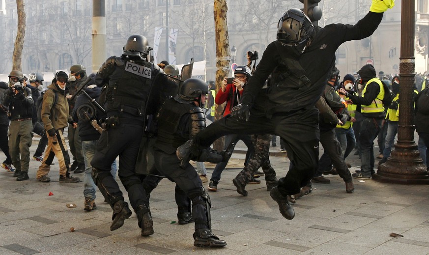 Ein Protestierender der «Gelbwesten» attackiert einen Polizisten auf der Champs-Elysées.