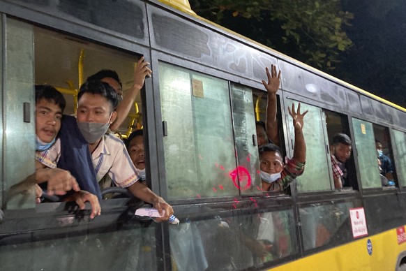 People wave from a bus after being released from Insein Prison in Yangon, Myanmar, Monday, Oct. 18, 2021. Myanmar's government on Monday announced an amnesty for more than 5,600 people arrested for ta ...