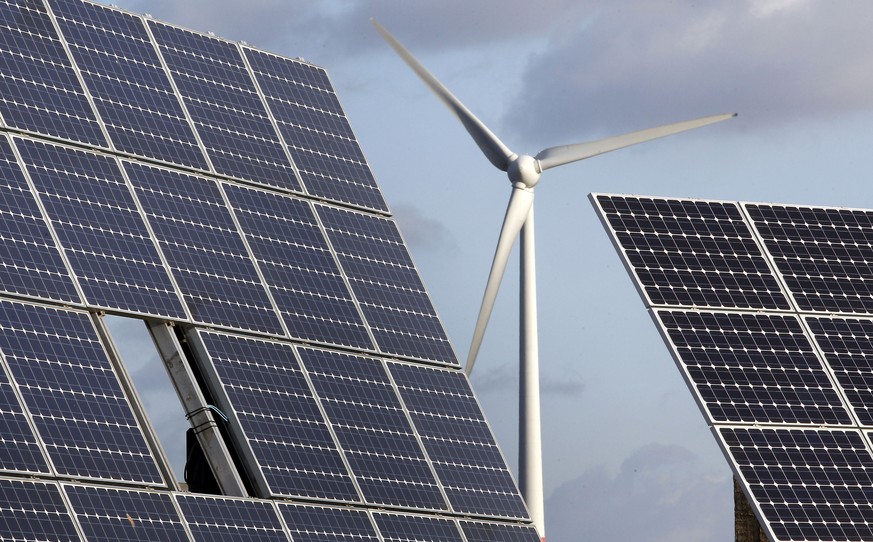 FILE - In this Nov. 30, 2011 file photo photovoltaic modules and a windmill of the wind farm are pictured at the village of Feldheim near Berlin, Germany. The crisis in Ukraine is underlining the urge ...