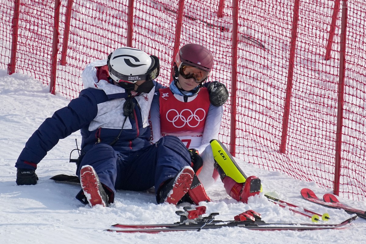 A team member consoles Mikaela Shiffrin, of the United States after she skied out in the first run of the women's slalom at the 2022 Winter Olympics, Wednesday, Feb. 9, 2022, in the Yanqing distr ...