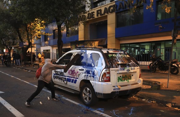 epa10013783 A young man attacks a police car during protests against the Government of Guillermo Lasso, in Quito, Ecuador, 14 June 2022. University students demonstrated outside a Unit of the Prosecut ...