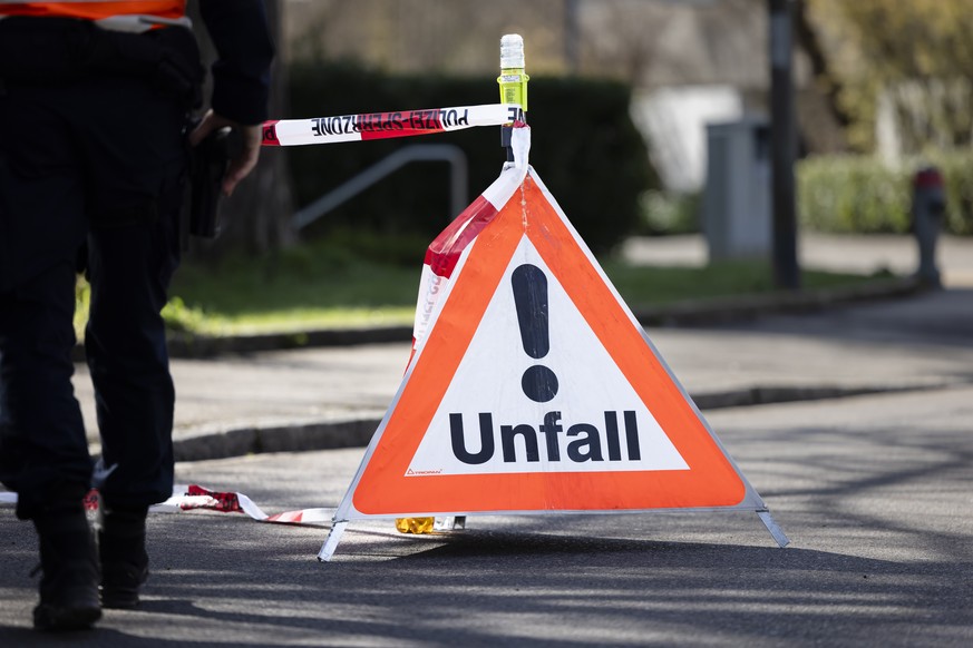 Ein Polizist geht an einem Triopan Faltsignal mit der Aufschrift Unfall vorbei, waehrend eines Einsatzes in Oberwinterthur, am Donnerstag, 14. Maerz 2024 in Winterthur. (KEYSTONE/Michael Buholzer)