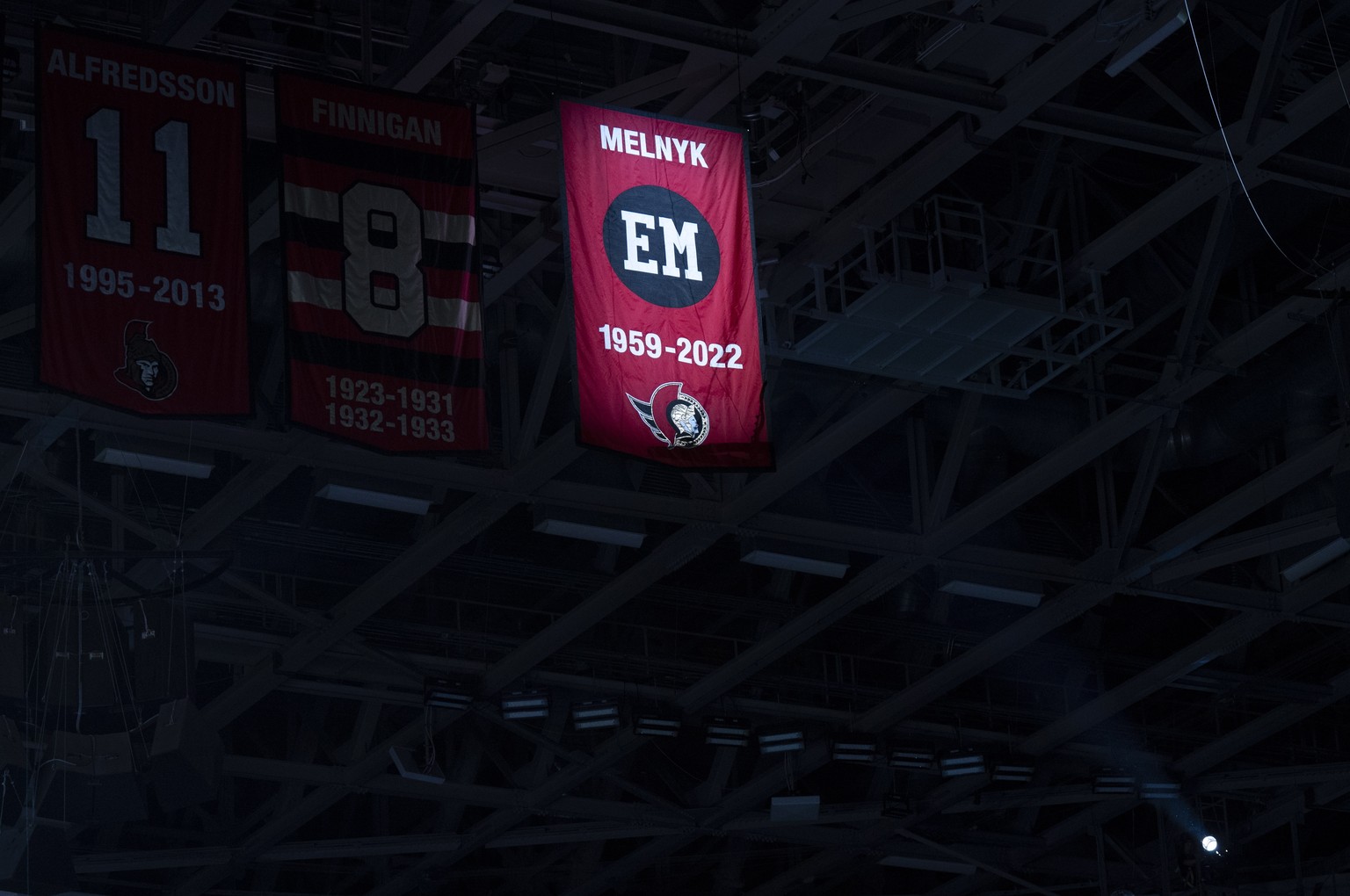 A light illuminates a banner honoring team Ottawa Senators owner Eugene Melnyk, who passed away earlier this year, during a ceremony before NHL hockey game between the Senators and the Washington Capi ...