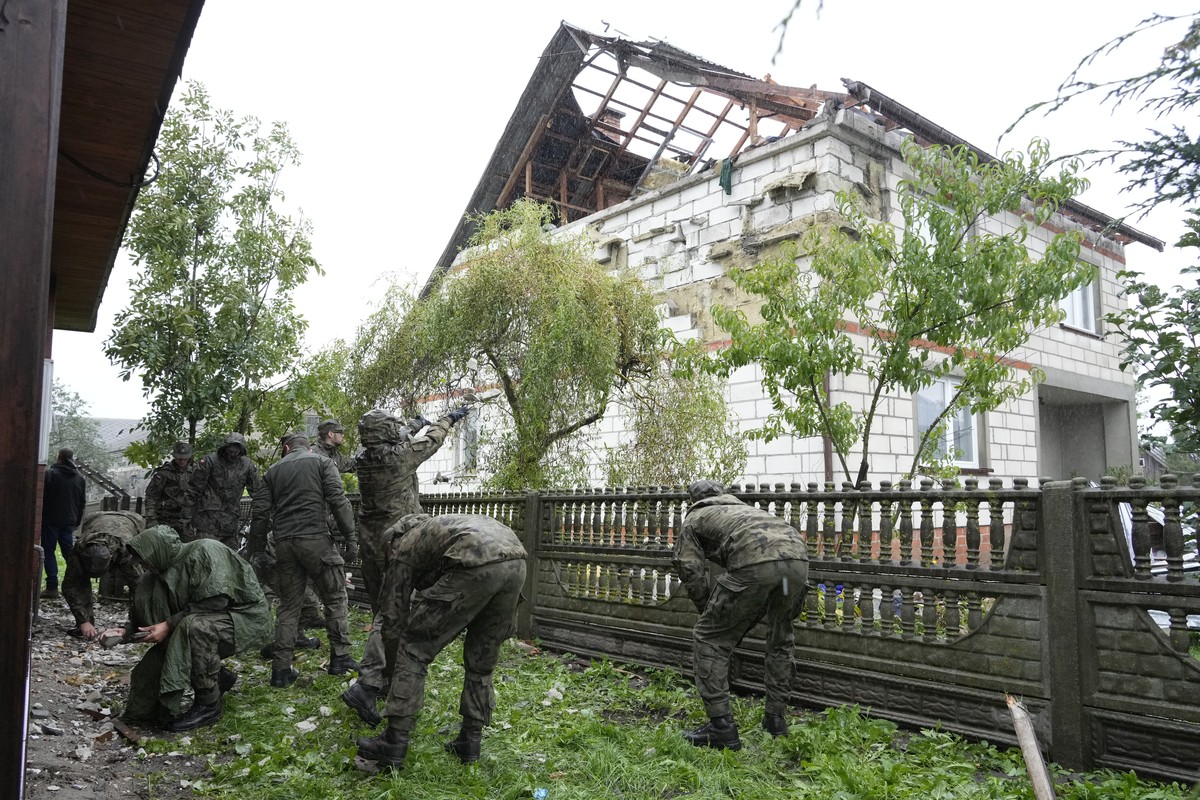 Territorial defense officers clean up debris from the destroyed roof of a house, after Russian drones violated Polish airspace during an attack on Ukraine, in Wyryki near Lublin, Poland, Thursday, Sep ...
