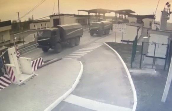In this image made from video provided by the Border Service of Ukraine, military vehicles pass a control point at the Armyansk checkpoint at the Ukraine-Crimea border, Thursday, Feb. 24, 2022. The Uk ...