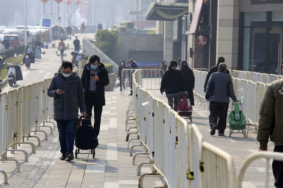 Shoppers with permits walk to a supermarket in Xi&#039;an in northwestern China&#039;s Shaanxi Province, Monday, Jan. 17, 2022. The first commercial airline flights in one month took off Saturday from ...