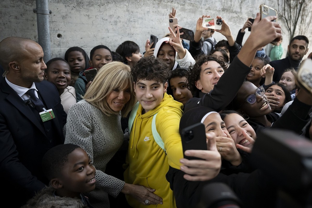 epa10976508 France's First Lady Brigitte Macron, takes a selfie with students, during a visit to the public school of french language (Ecole cantonale de langue fran�aise), in Bern, Switzerland,  ...