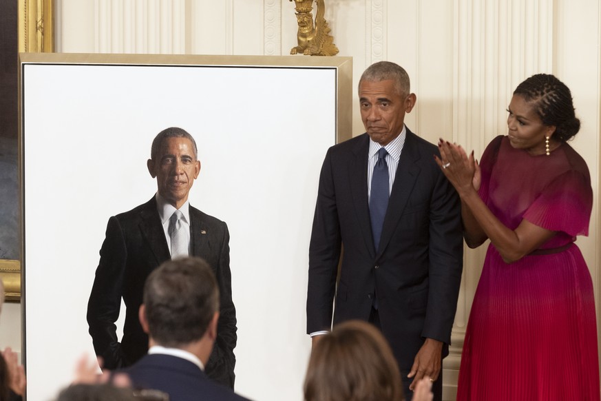 epa10168158 Former President Barack Obama (L) and former First Lady Michelle Obama (R) stand beside the official White House portrait of former President Obama, after it was unveiled in the East Room  ...